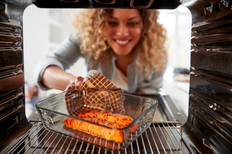 Woman cooking salmon in the oven