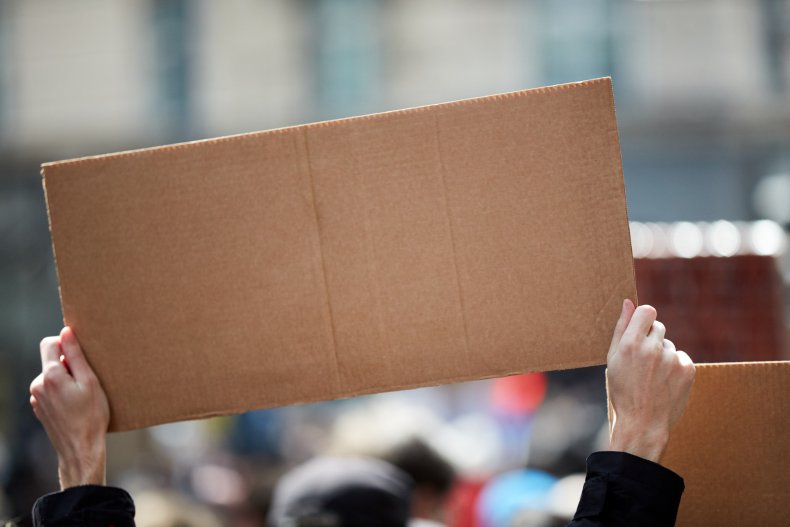 A cardboard sign being held up.