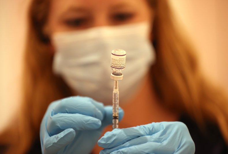 pharmacist fills a covid booster shot