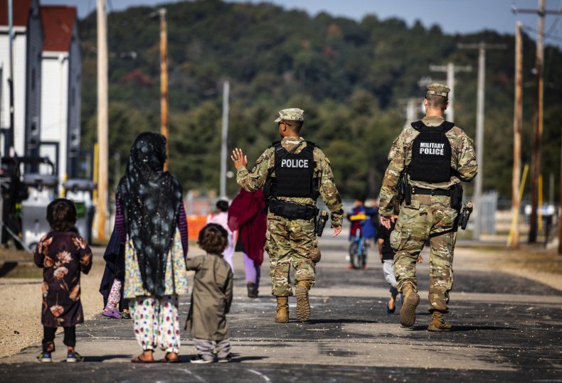 U.S. Military Police walk past Afghan refugees 