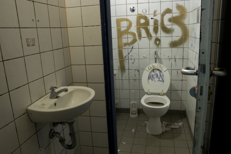A graffiti-ed and vandalized bathroom. 