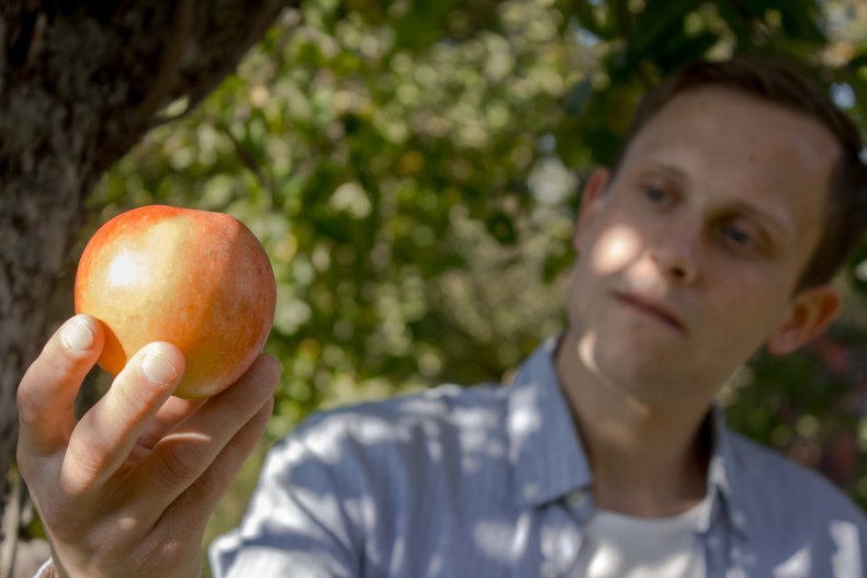 A man holding an apple. 