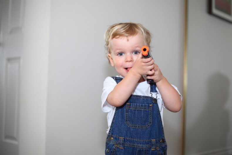 Toddler holding nerf gun