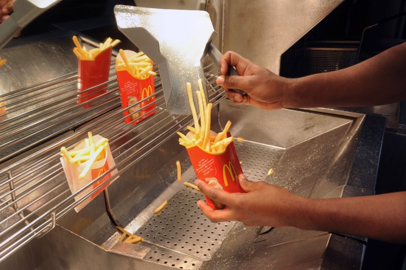 Photo of McDonald's worker serving fries. 