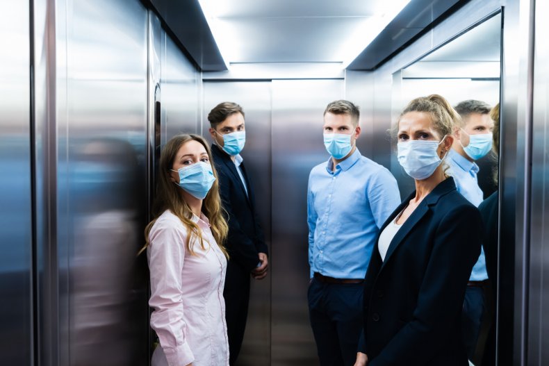 people in elevator wearing masks