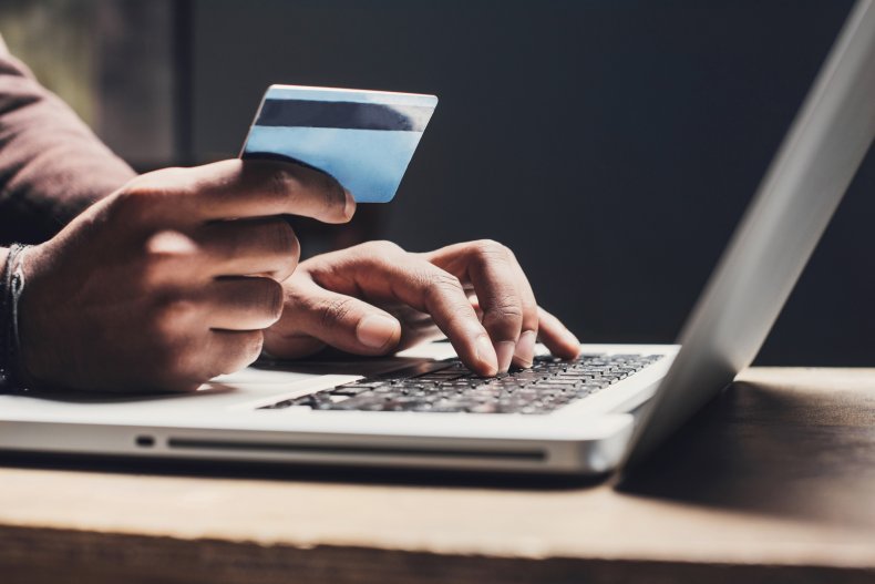 Person holding credit card over laptop