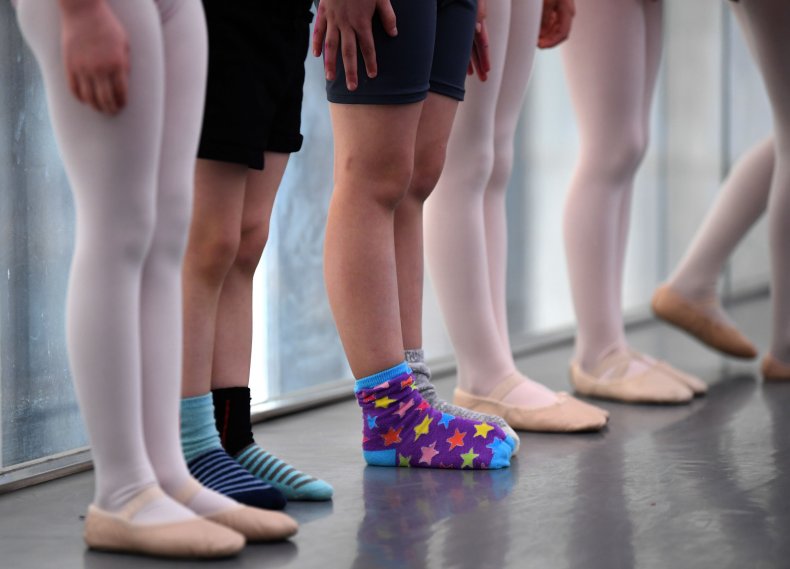 A row of ballet dancers' legs.