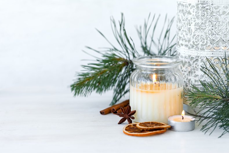 A candle next to Christmas-themed spices/aromas.
