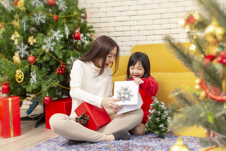 A woman and child opening Christmas gifts.