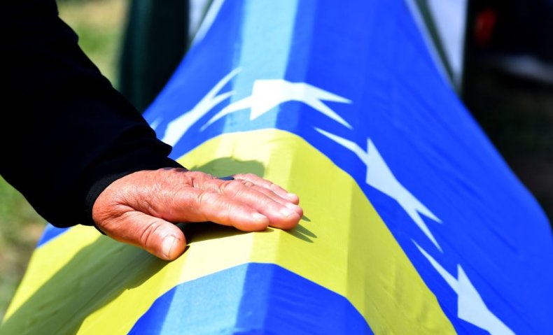 Bosnian woman touches casket