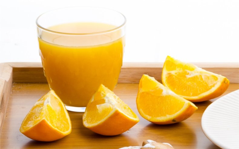 A glass of orange juice and oranges.