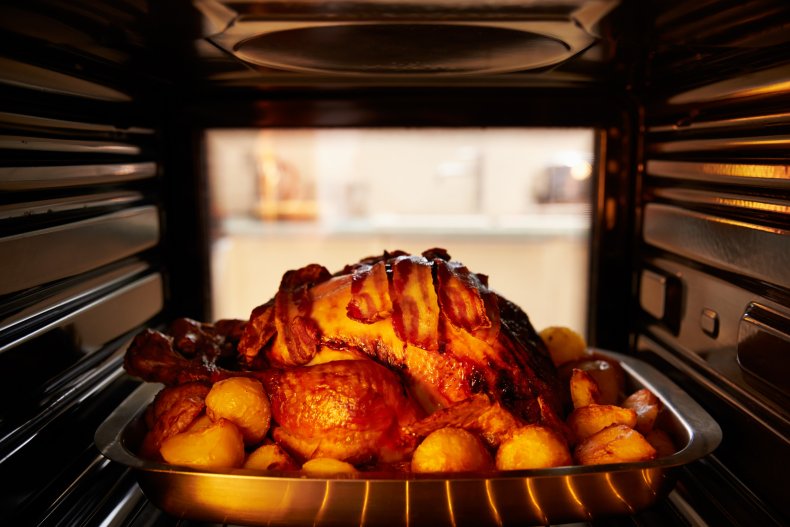 A turkey cooking inside an oven.