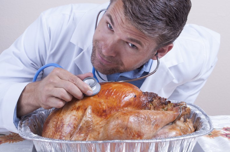 Doctor with stethoscope on baked Thanksgiving turkey.