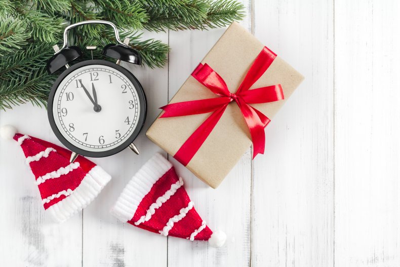 A clock seen next to Christmas gifts.