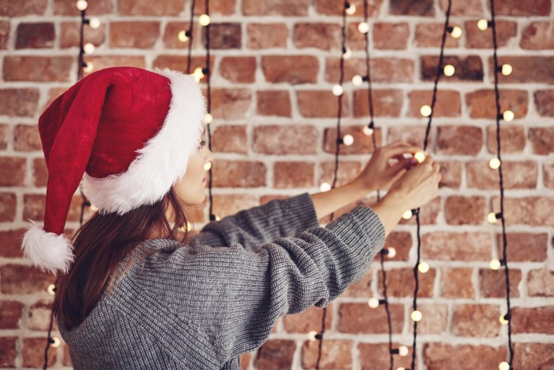 A woman hanging Christmas lights.