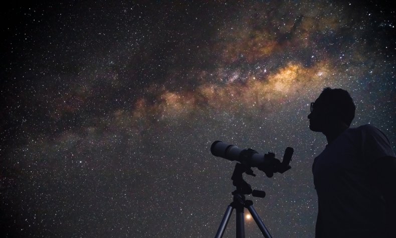 Uomo che punta il telescopio al cielo
