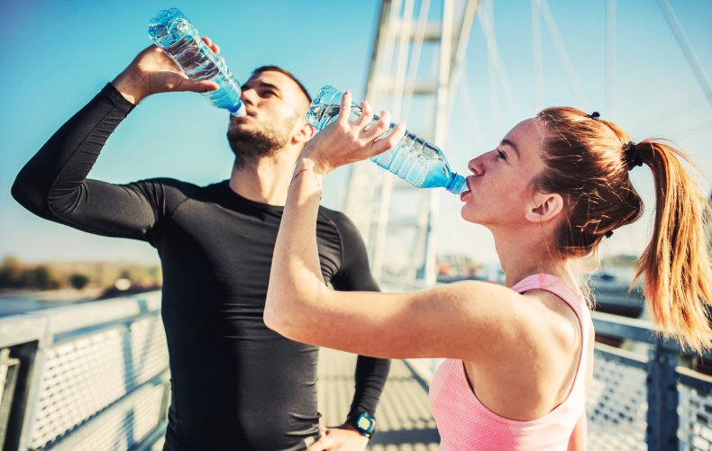 Two people drinking water after exercise. 