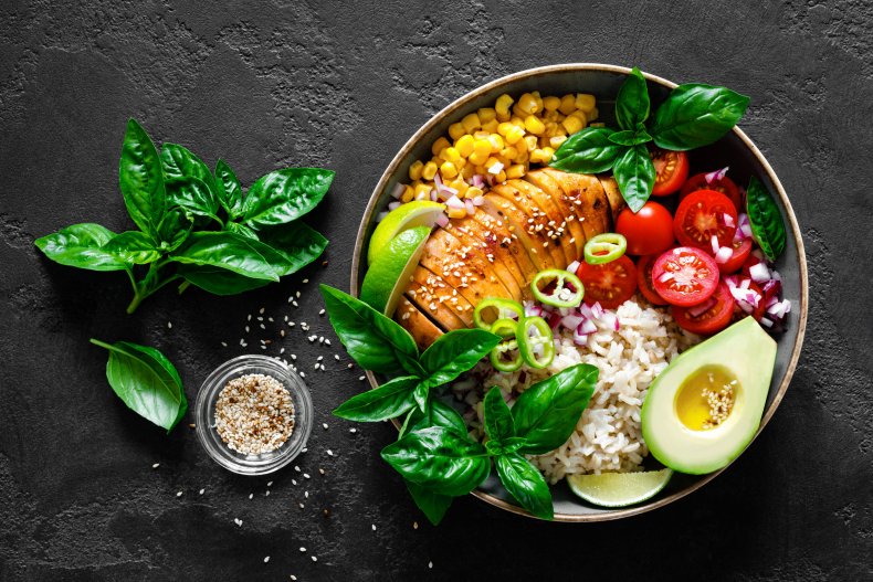 A bowl of vegetables, chicken breast, rice.