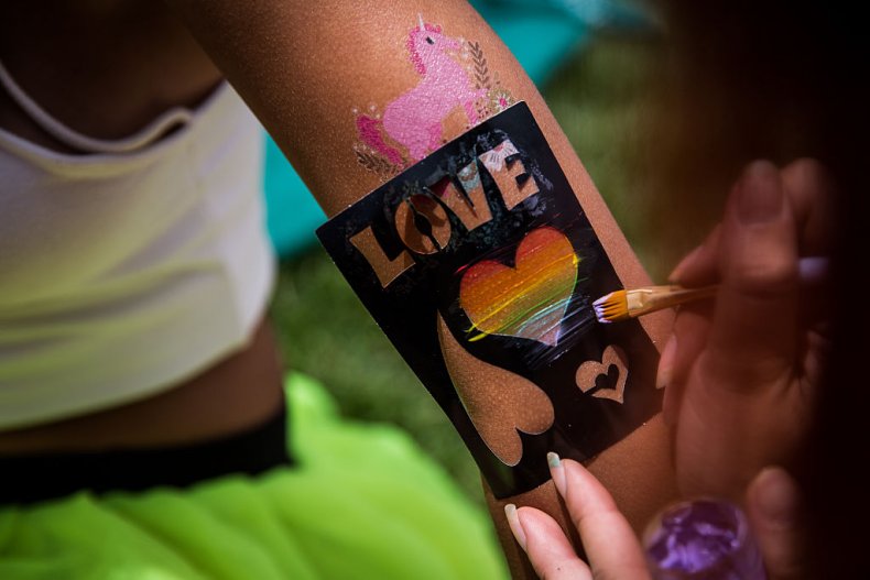 A person gets a rainbow heart stencil