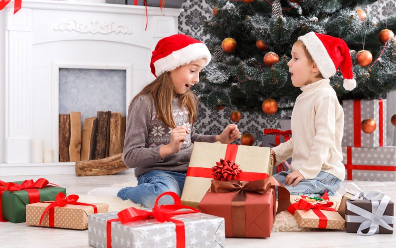 A girl and boy opening Christmas presents.