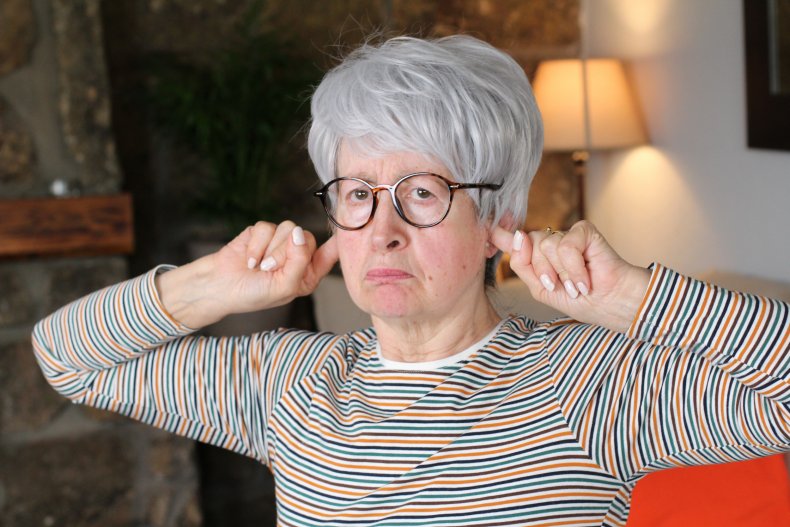 File photo of woman holding her ears.