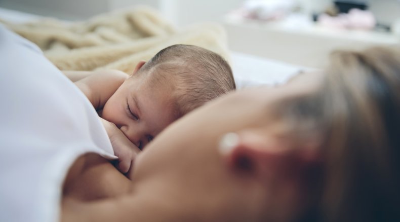 Mother lying next to her newborn baby