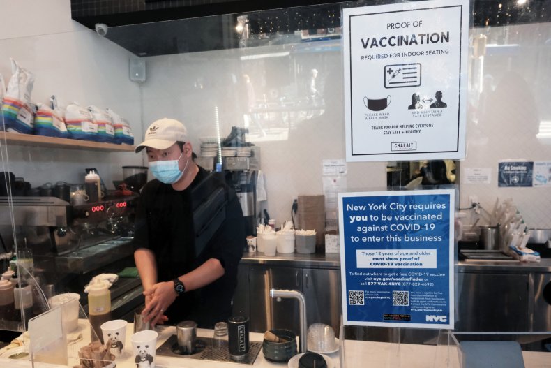 Masked employee works at NYC coffee shop