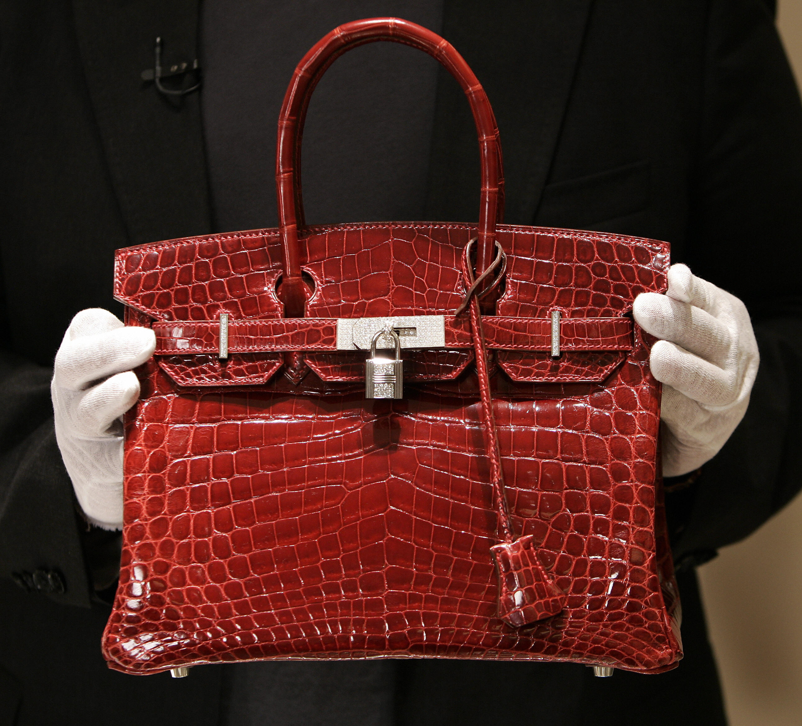 A Birkin luxury handbag sits in the window display of a Hermes