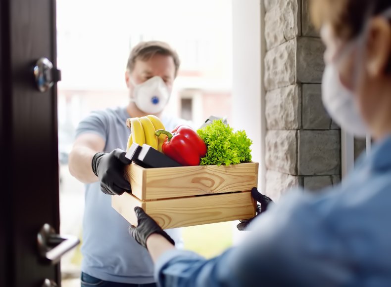 A courier delivering groceries to a woman.