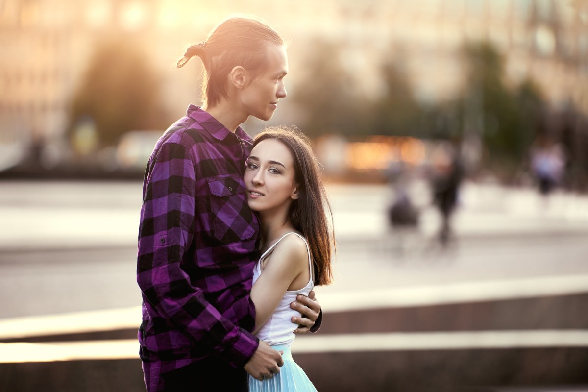 A tall man hugging a short woman.