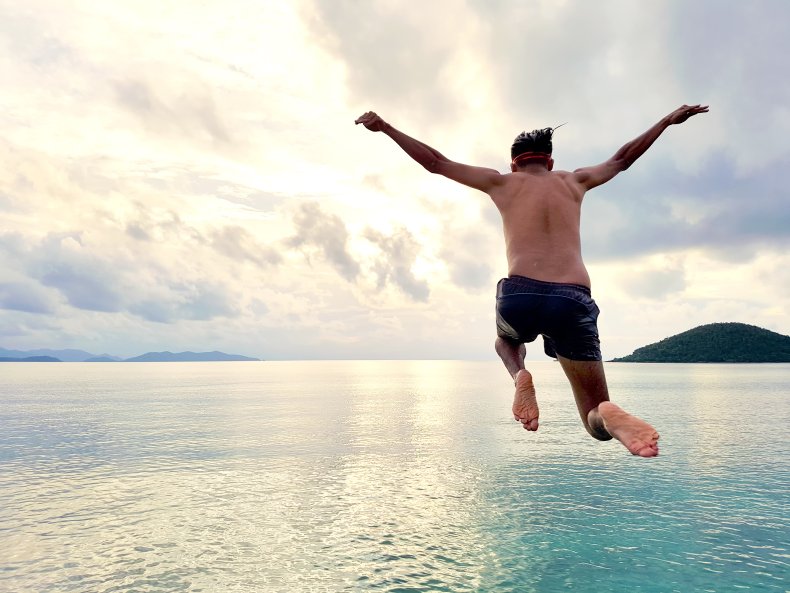 man jumping into ocean