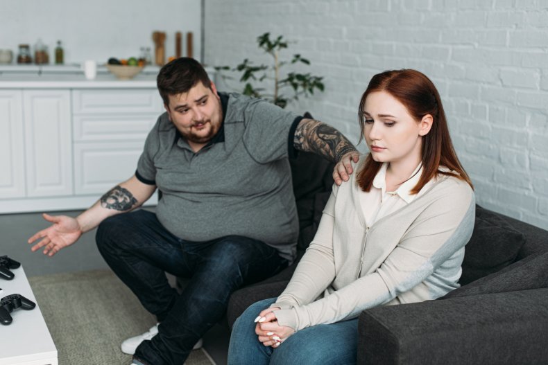 An overweight man consoling his female partner.