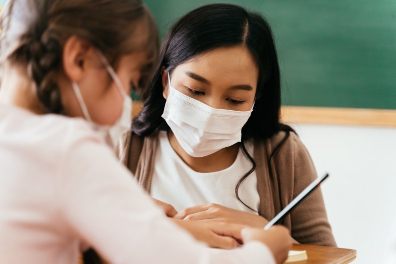 A female teacher wearing a face mask.