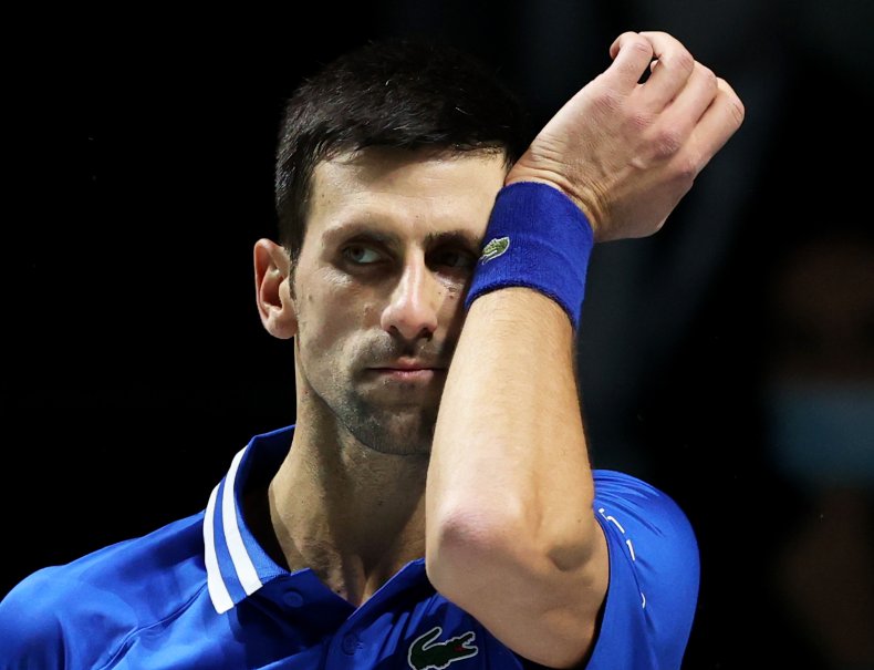 Novak Djokovic wipes his forehead.