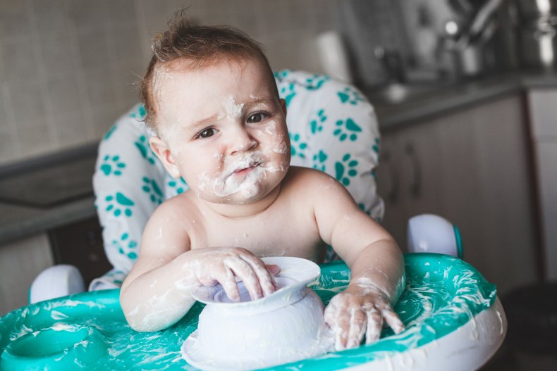 A baby with yogurt on their face.