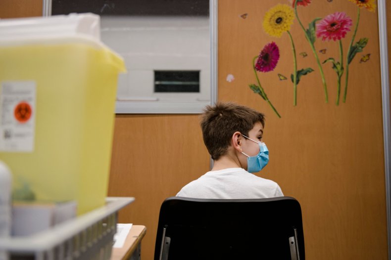 A child waits after receiving vaccine