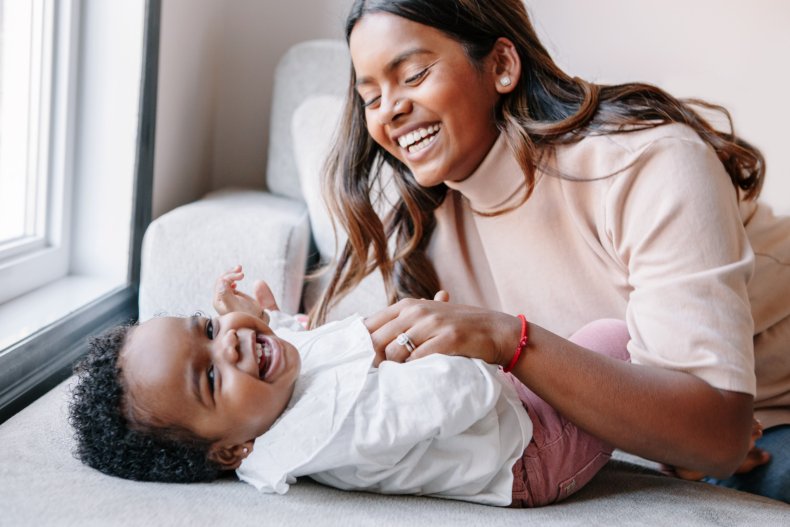 A mother looking at a smiley baby.
