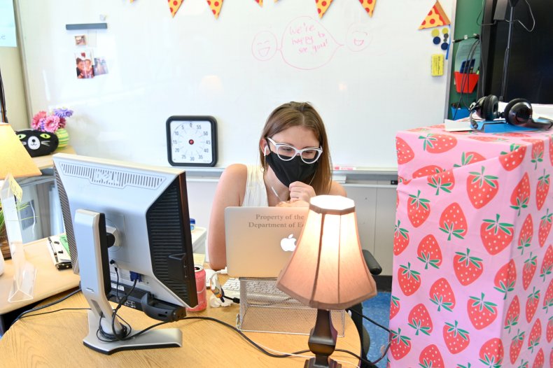 A teacher wears a mask and teaches