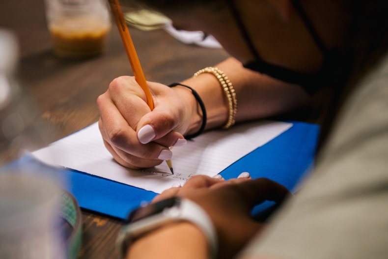 A student takes notes during instruction