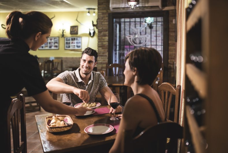 Waitress serving couple at table