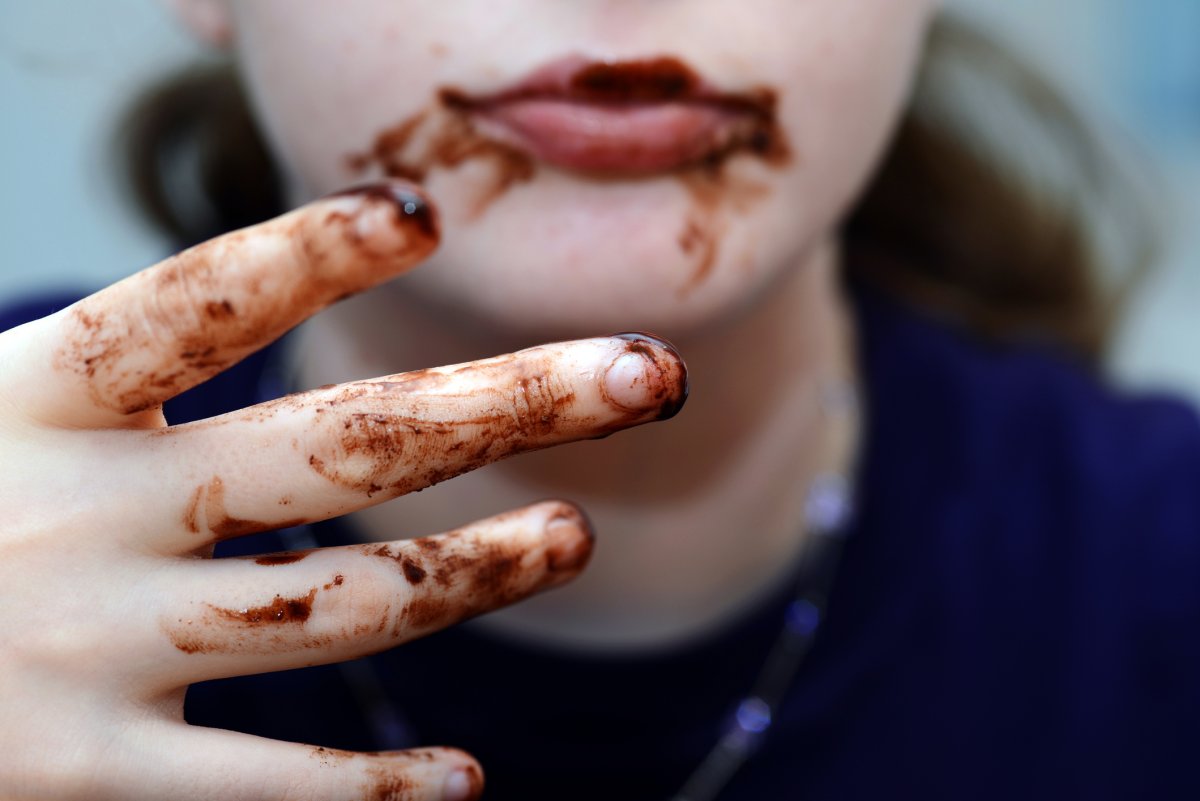 A woman with chocolate on her fingers.