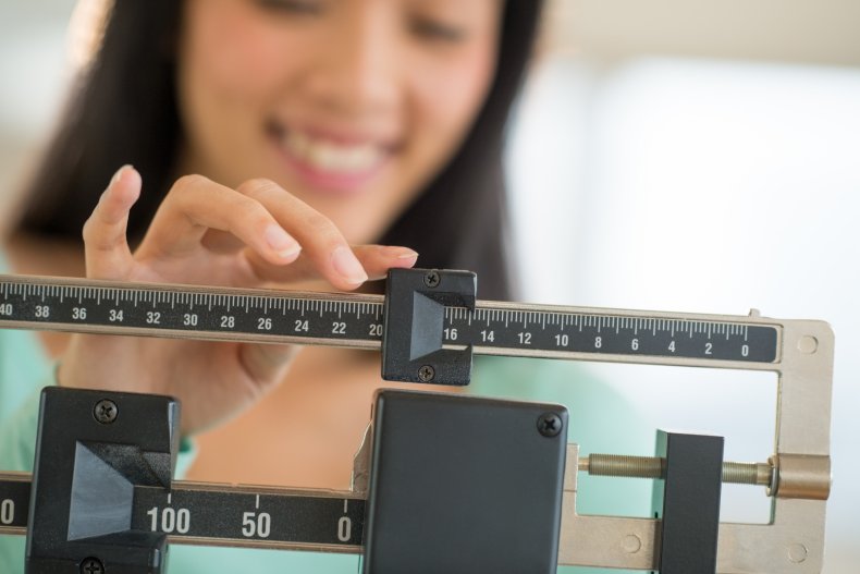 A woman using a weight scale.