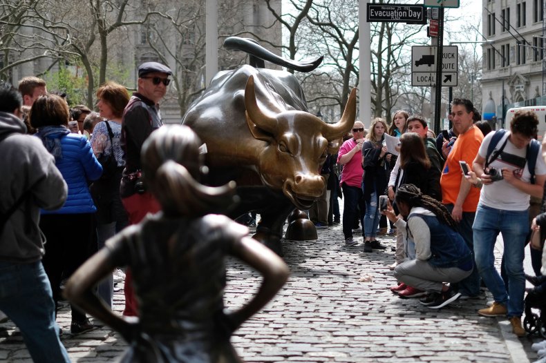 The "Fearless Girl" (L) statue stands facing