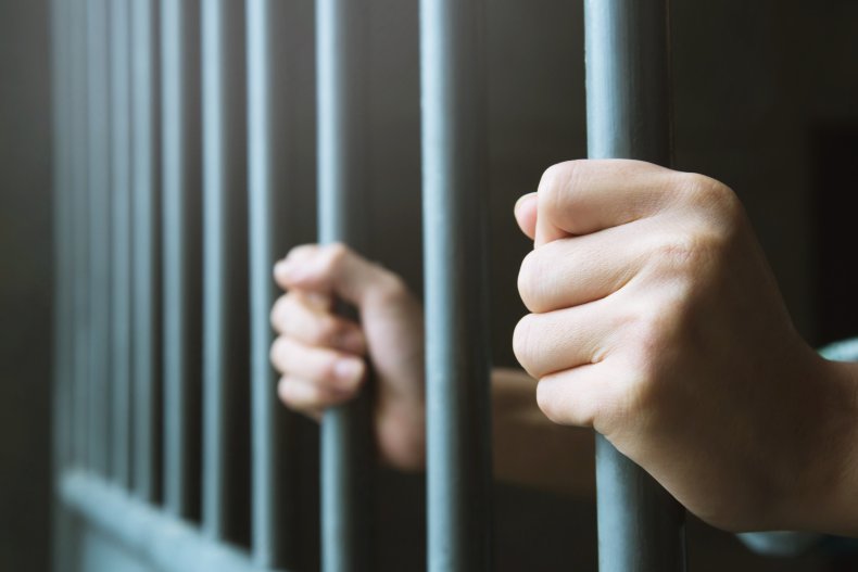 Man holding bars in prison