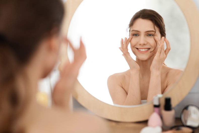 A woman applying eye cream.