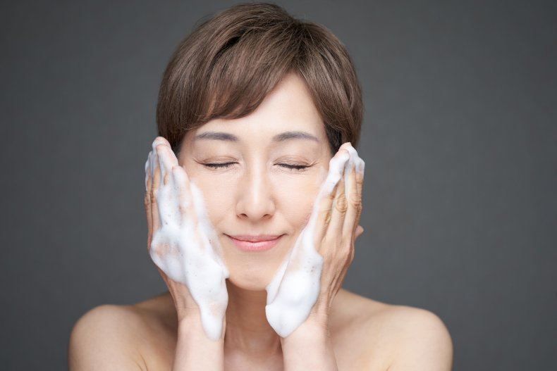 A woman washing her face with soap.