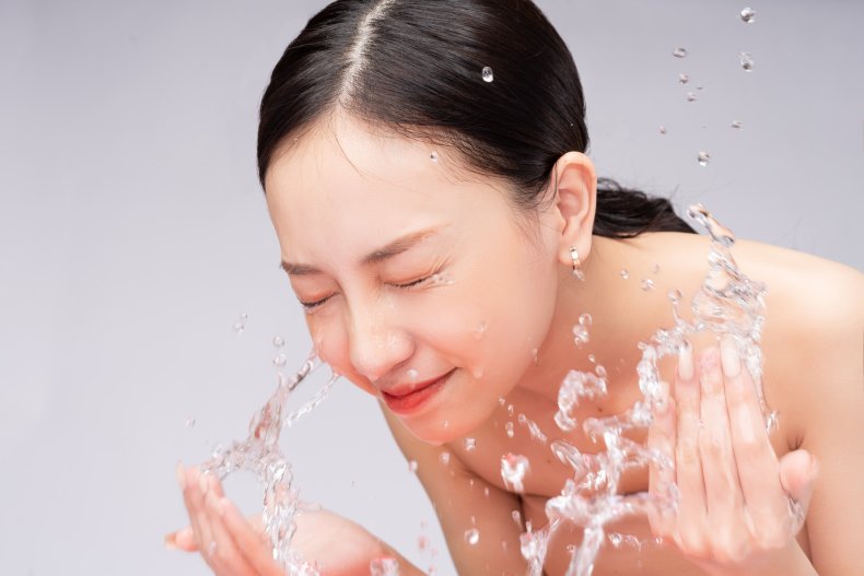 A woman splashing her face with water. 