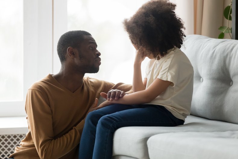 A dad consoling their upset child.
