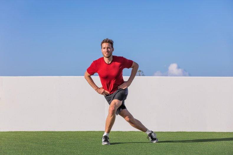 A man doing a curtsy lunge.