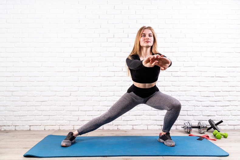 A woman performing a side lunge move.
